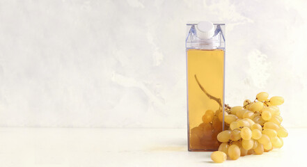 Mock up bottles with grape juice on a gray background. Nearby is a bunch of ripe grapes. Banner. Copy space