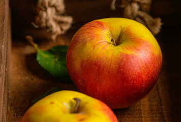 Close up view of two regular red apples on a wood basket. Food photography detail.