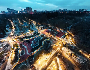 Aerial view Kharkiv city center popular recreation park Sarzhyn Yar with illumination and residential district. Botanical garden water spring and playground at night