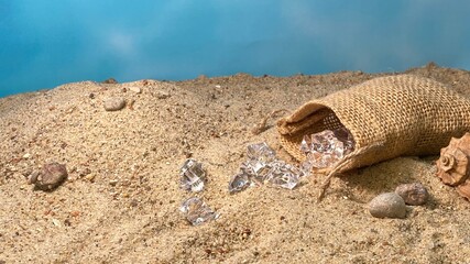 Crystals falling out of the jute bag on the sand visible stones and shells © Józef