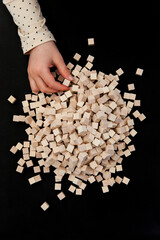Child holds wooden building blocks in hand.
Free play with wooden cubes.
Kind hält hölzerne...