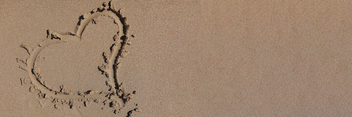 Heart is drawn on wet sand on beach. Services of travel companies concept
