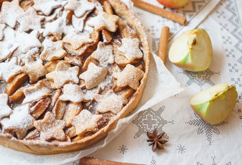 Traditional apple pie on the table with decorations.