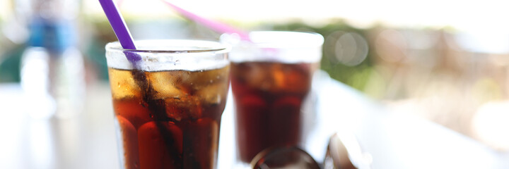 Table two dark colored cocktails with straw. Refreshing drinks in summer concept