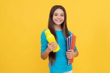 cheerful child girl hold notepad for homework and juice bottle, lunch