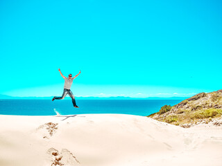 Obraz na płótnie Canvas man jumps on the Sand dune of Bolonia beach, province Cadiz, Andalucia, Spain