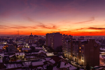Fototapeta na wymiar Incredible sunset on the winter city. Evening illuminated city and sunset