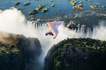 Foto op Aluminium Tourists fly over the Victoria Falls on the trikes. Africa. Zambia. Victoria Falls. © gudkovandrey