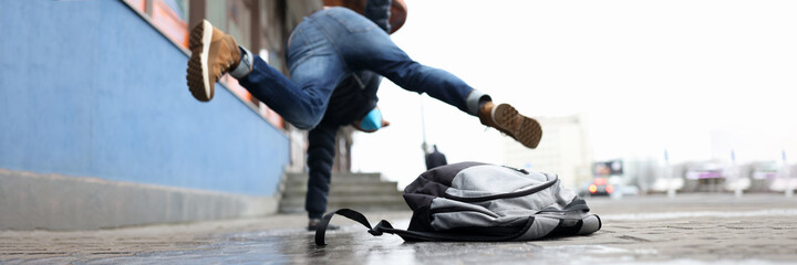 Man in winter dress slip on sidewalk with ice closeup background. Heath insurance concept