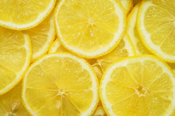 Fruit background, top view. Juicy yellow lemon cut into round slices. 