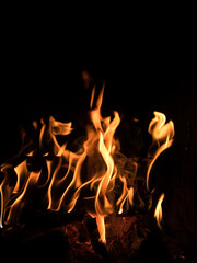 Burning wood, embers and flames in a fireplace, focus at burning wood