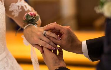 Wedding rings in the hands of the bride and groom. Wearing wedding rings, gentle touches, hands of the bride