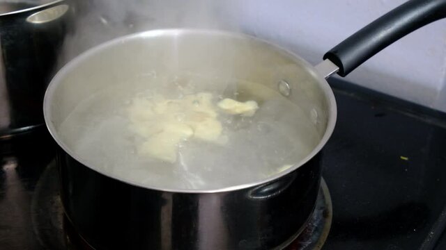 Boiling gnocchi in a large steel pan. A traditional italian food