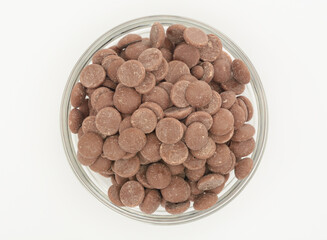 Cobertura de chocolate con leche en un bol de cristal sobre fondo blanco, visto desde arriba