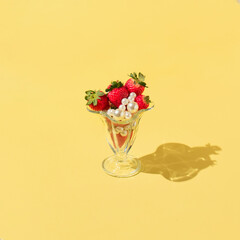 Creative concept with strawberries, white pearls  and glass jar on bright yellow background. Minimal fruit or food concept. Sweet happy spring idea.
