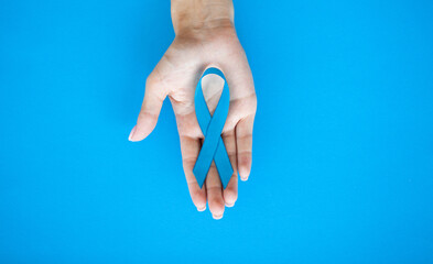 Blue ribbon in hand, prostate cancer awareness