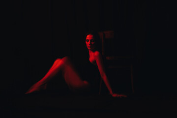 blurry young sexy girl in black bodysuit with red neon light