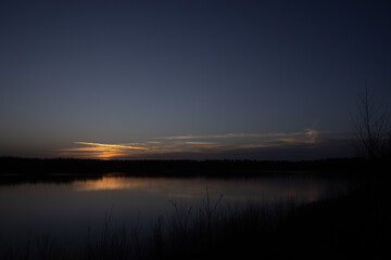 Obraz premium Dramatic and colorful sunset over a forest lake reflected in the water. Blakheide, Beerse, Belgium. High quality photo