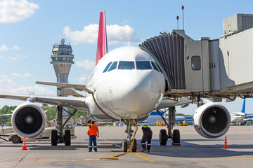 The aircraft is attached to the terminal gangway of the airport building while refueling before the...