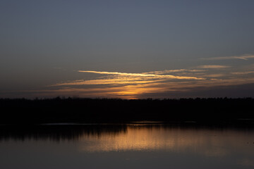 Dramatic and colorful sunset over a forest lake reflected in the water. Blakheide, Beerse, Belgium. High quality photo