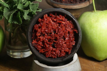 bowl with hookah tobacco. berries on a black background. nargile smoking