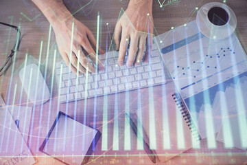 Multi exposure of man's hands typing over computer keyboard and forex graph hologram drawing. Top view. Financial markets concept.