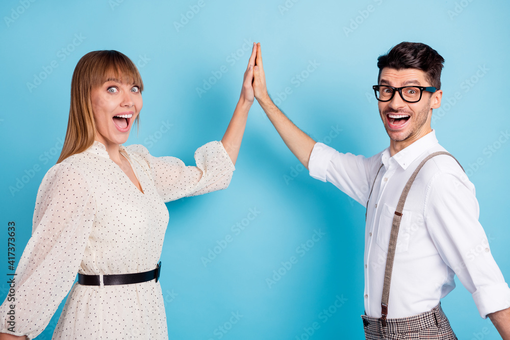 Wall mural photo of impressed funny two persons dressed white clothes giving high five open mouth isolated blue