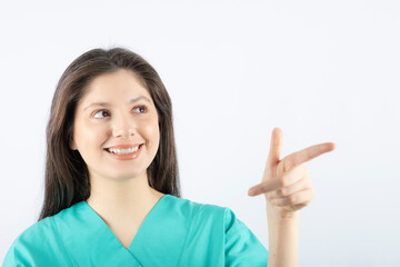 Image of a smiling young woman model pointing away