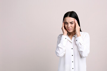 Portrait of stressed young woman on beige background. Space for text