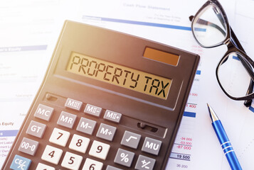 Word PROPERTY TAX on the display of a calculator on financial documents.