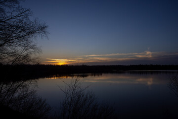 Dramatic and colorful sunset over a forest lake reflected in the water. Blakheide, Beerse, Belgium. High quality photo