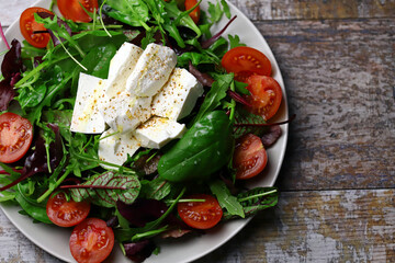 Delicious salad with feta cheese and cherry tomatoes. Healthy diet. A plate of salad. Spring food.