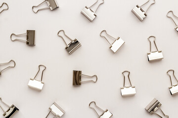 Flat lay of paper binder clips, office supplies pattern