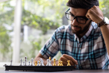 Man developing chess strategy, playing board game.
