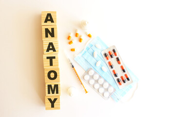 The word ANATOMY is made of wooden cubes on a white background. Medical concept.