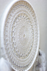 Handmade dream catcher with feathers threads and beads rope hanging on white background