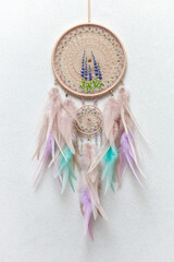 Handmade dream catcher with feathers threads and beads rope hanging on white background