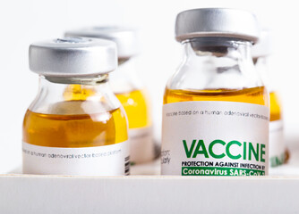Vials of coronavirus medicine are in packaging on a white background. Vaccine test concept in a laboratory, macro