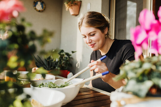 Young woman serving salad