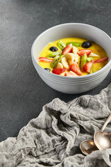 Mango soup with fresh berries and fruits. Asian dessert food on dark slate background. Chinese, asian, authentic food concept