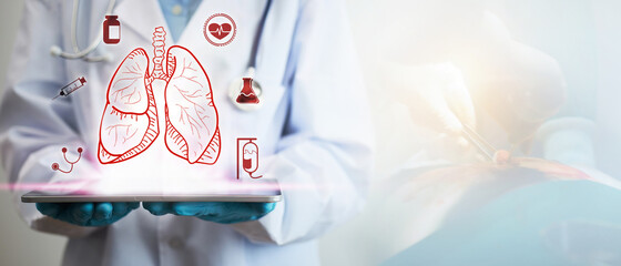 Concept of lung disease treatment. A doctor's hand holding a tablet showing a lung icon.