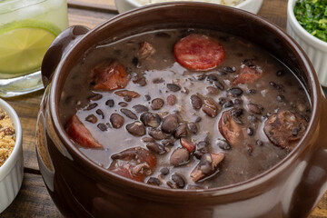 Traditional brazilian feijoada with kale, manioc flour and caipirinha