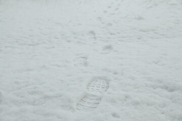 Bootprints in snow outdoors on winter day