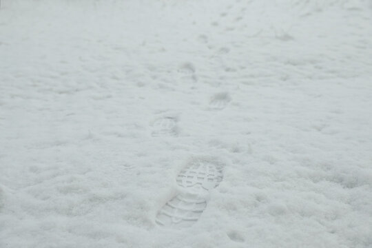 Bootprints in snow outdoors on winter day