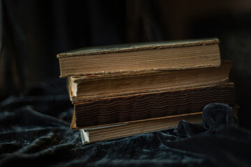 endpaper of vintage books, collection of old antique ancient books on black background, vintage books on black velvet fabric as background, velvet background, copy space