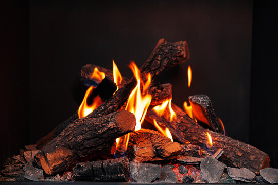 Wood logs burning in fireplace close up