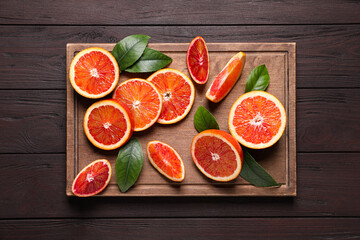 Slices of fresh ripe red oranges on wooden table, top view