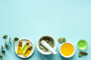 Herbal medicine and natural cosmetics. Eucalyptus leaves with white mortar, top view