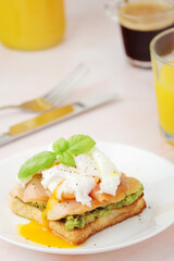 Breakfast with a sandwich with poached egg and avocado