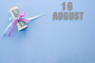 calendar date on blue background with rolled up dollar bills pinned by blue and pink ribbon with copy space. August 16 is the sixteenth day of the month
